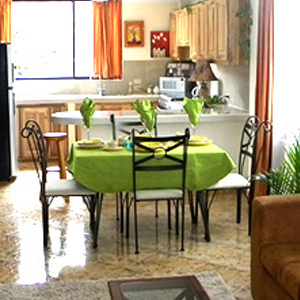 Photo of dining area showing a table with green table cloth and four chairs