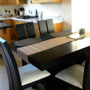 Photo of dining area showing a wooden table with black chairs